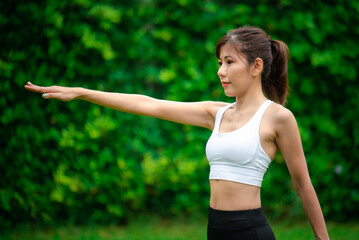 Fototapeta premium Young asian women warm up in a park before jogging.