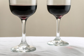Two large glasses with red wine on a blurred background, close-up. Horizontal photo