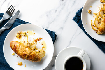 Morning coffee with croissants stuffed with caramelized pear, hazelnuts, and ricotta. Flat lay food.