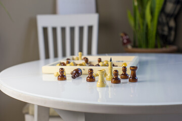 Chess figures with board on white table at home .To do at home at coronavirus quarantine. Home games. Education for kids. Chess figures on white background. Comfort zone for board game. Kid occupation