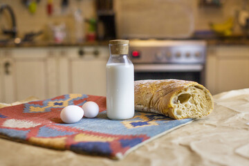 Basic  products for food and simple life. Ingredients for cooking. Bottle of milk, eggs and bread. Food for usual simple breakfast in white kitchen. Organic food. Farmer's food. Simple eating.