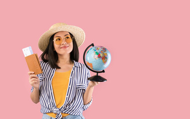 Asian woman holding passport with boarding pass and globe