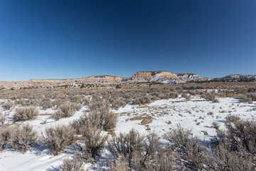 Snow covered desert with mountain range with clear blue sky in rural New Mexico