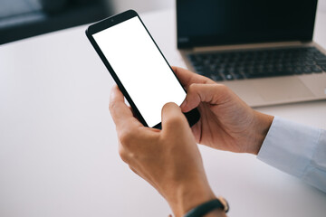 Entrepreneur browsing smartphone in hands