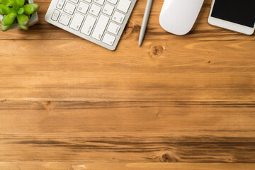 Overhead close up view photo image of cellphone pen white keyboard mouse and green succulent isolated light loft brown backdrop with empty space