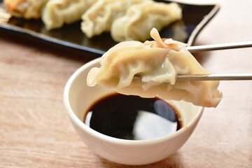 steamed Gyoza or Japanese dumpling stuffed minced pork dipping shoyu sauce on plate