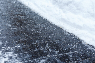 Anti-ice reagent on the dark surface of the pavement.