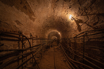Ancient cable collector. Brick arched cable collector of the 19th century. With warm lighting.