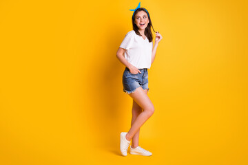 Full length photo of girl play curl look empty space wear blue headband white t-shirt mini shorts footwear isolated yellow color background