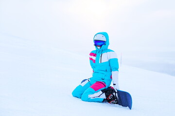 Fototapeta na wymiar woman snowboarder posing with snowboard on the slope