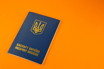 Ukraine official passport on an orange background. The national emblem is depicted. The inscription in Ukrainian.