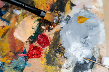 Obraz premium Paintbrush and palette with colored oils from an artist at home relaxed