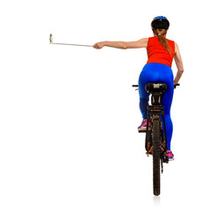 Rear view of young athletic woman in sportswear taking photo on bike, video blogger filming himself while cycling