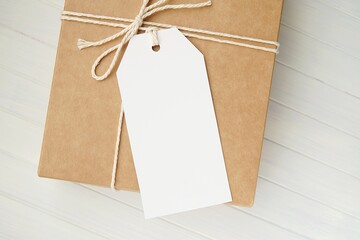 Blank gift tag mockup on brown present box, plain price tag or label mock up. - Powered by Adobe