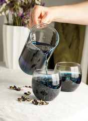 Cups of butterfly pea flower tea with  on grey background. Healthy concept
