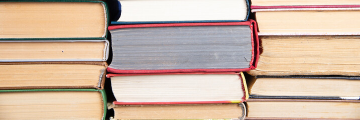 Many stacks of books. Old hardback books as background. Back to school