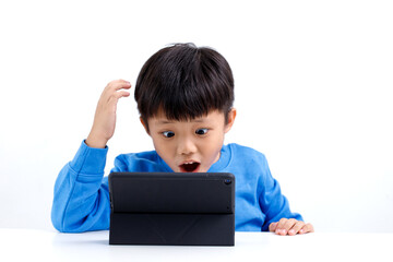 Shocked and surprised little Asian boy on the internet with tablet computer isolated on white background.
