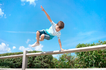 boy jumping over the fence. Sports and activities for young people. Childhood and leisure. Freedom...