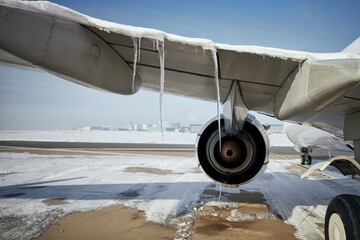 Selective focus on icicles from airplane in frosty day. Grounded plane at snowy airport. One of the...