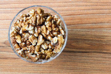 Walnuts peeled in a bowl on a wooden surface
