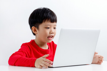 Portrait of a cute little Asian boy using laptop at home, online, video chatting, education,...