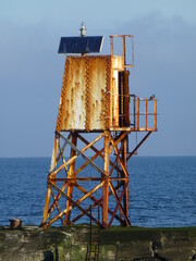 Rusting navigational beacon at entrance to Ayr harbour, Scotland