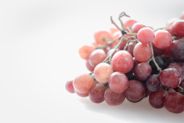 Ripe red grapes on a white background