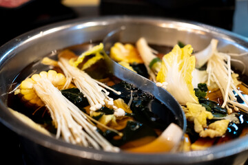Double flavor hot pot there are consist of vegetables such as mushroom, corn, lettuce and seaweed.