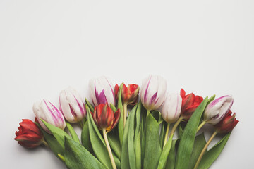Bouquet of tulips flowers on white table. Mothers day, Easter, womens day, spring natural background. Top view, flat lay, copy space