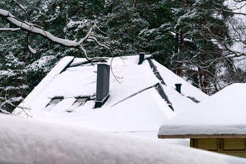 White snow is falling on the roof covered with snow.