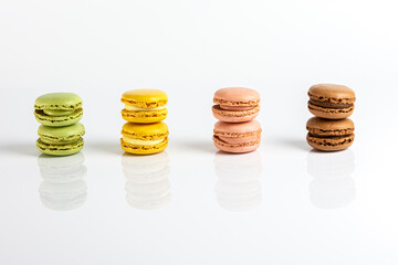 Multicolored macarons lined up on a white background