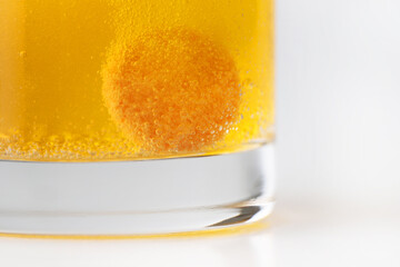 Orange effervescent tablet dissolving in water