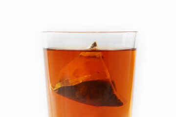 A glass of tea with tea bag isolated on white background.