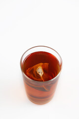 A glass of tea with tea bag isolated on white background.