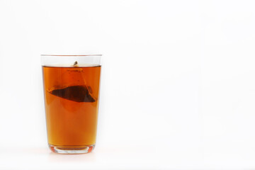 A glass of tea with tea bag isolated on white background.