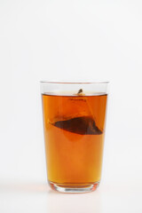 A glass of tea with tea bag isolated on white background.
