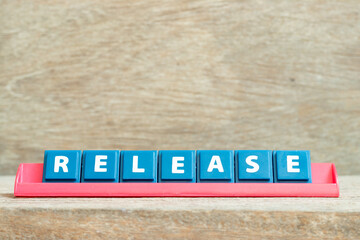 Tile alphabet letter with word release in red color rack on wood background