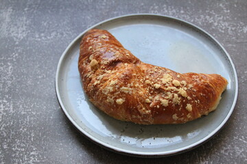 sweet French croissant, desert, puff pastry, croissant on a round plate, cone