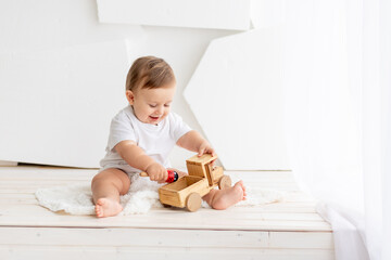baby boy playing wooden toy typewriter at home, the concept of play and development of children