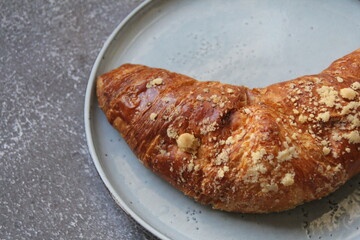 sweet French croissant, desert, puff pastry, croissant on a round plate, cone