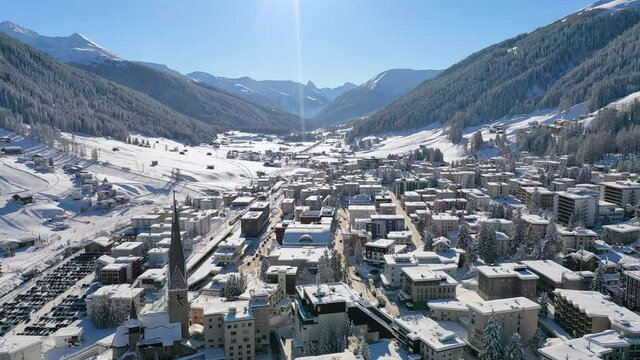 Davos, Switzerland: Aerial view of famous Swiss Alpine ski resort town in winter, buildings and slopes covered in snow - landscape panorama of Alps mountain range from above, Europe