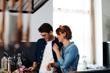 Laughing couple making dinner