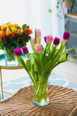 A bouquet of pink rose and purple tulip flowers inside a house close up detail view