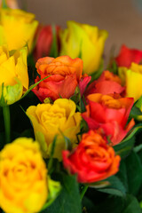 A bouquet with a lot of red orange and yellow roses on a table interior photography