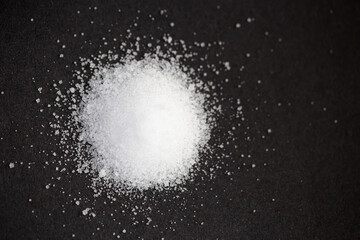 White sugar on black background. selective focus