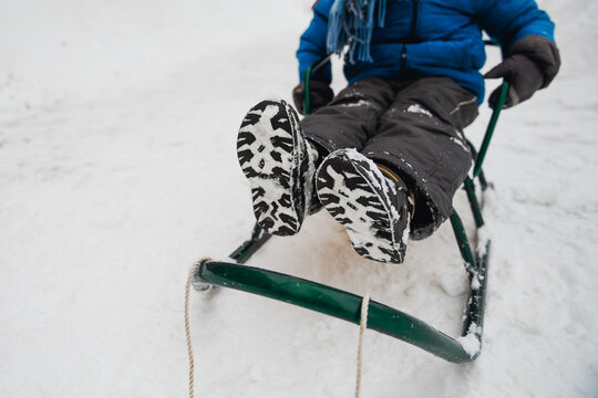 Close up of child's feet  in boots covered with snow. 