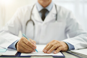 Doctor hands filling in patient medical chart