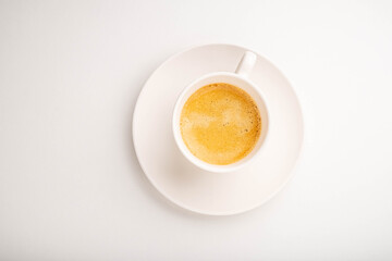 .Espresso in a white cup on a white background. View from above