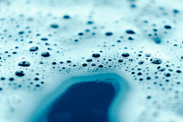 Soap bubbles on a background of blue water as a texture. Copy, empty space for text