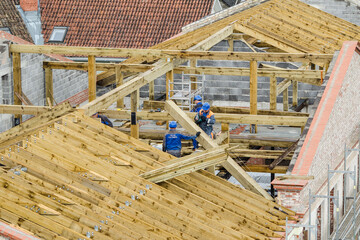 Workers roofers builders working on roof structure on construction site